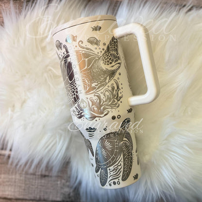 A white ceramic mug with a handle and a design featuring a turtle and other marine life.