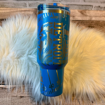 A blue tumbler with a Detroit-themed design, featuring a lion and the word "Detroit" prominently displayed.